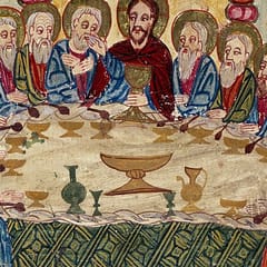 Christ, in a red robe, sits at the center of a long table holding a golden chalice, surrounded by haloed apostles, with cups, a jug, and a wide bowl set on the white cloth.