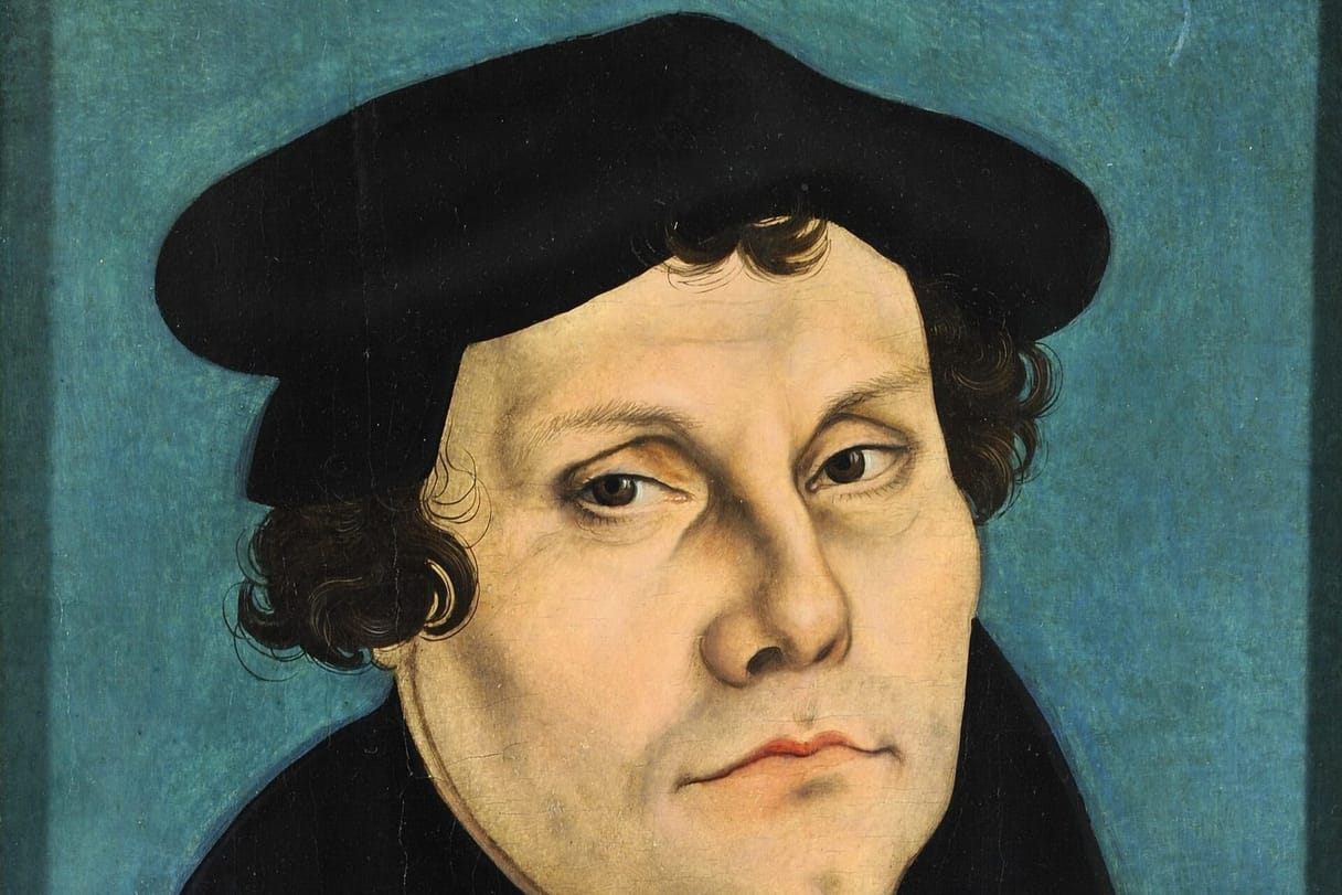Martin Luther, in a black cap and gown, gazes to one side against a teal background.