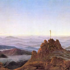 Morning light spreads over range after range of misty blue mountains, with a small cross standing on a rocky summit in the foreground.