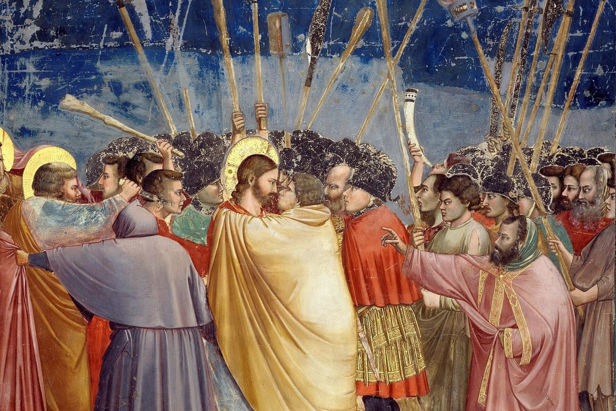 Judas, wrapped in a yellow cloak, kisses Christ in a crowd of soldiers raising torches, clubs, and lances; at the left, Peter seizes a man and cuts at his ear with a knife.