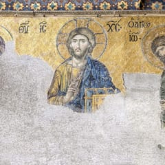 A gold mosaic of Christ holding a book and raising his hand in blessing, between the Virgin Mary and John the Baptist, who turn toward him; the lower half of the mosaic has been lost to bare plaster.