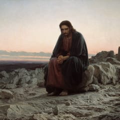 Jesus sits alone on a rock in a stony desert at dawn, his hands clasped tightly in prayer and thought.