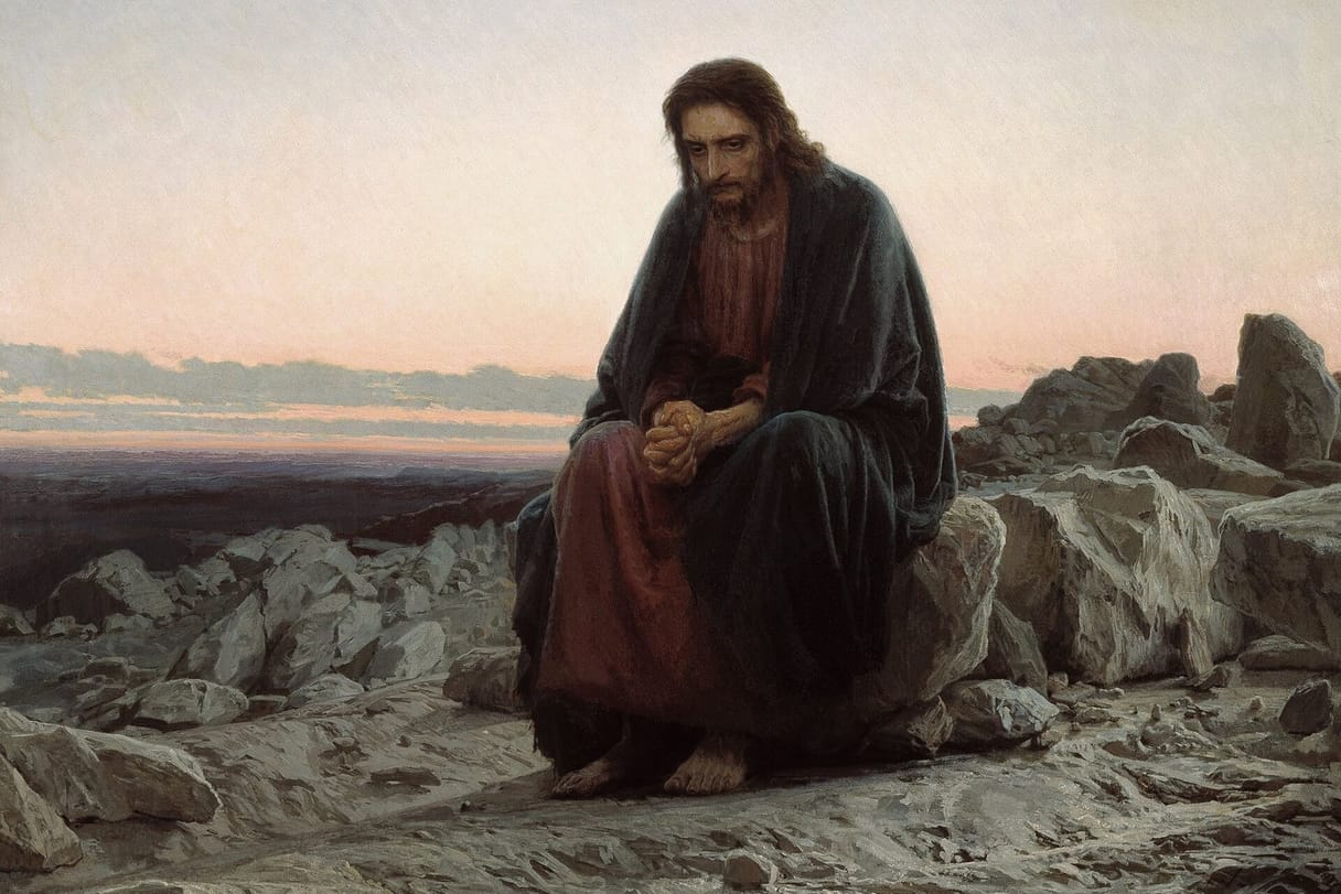 Jesus sits alone on a rock in a stony desert at dawn, his hands clasped tightly in prayer and thought.