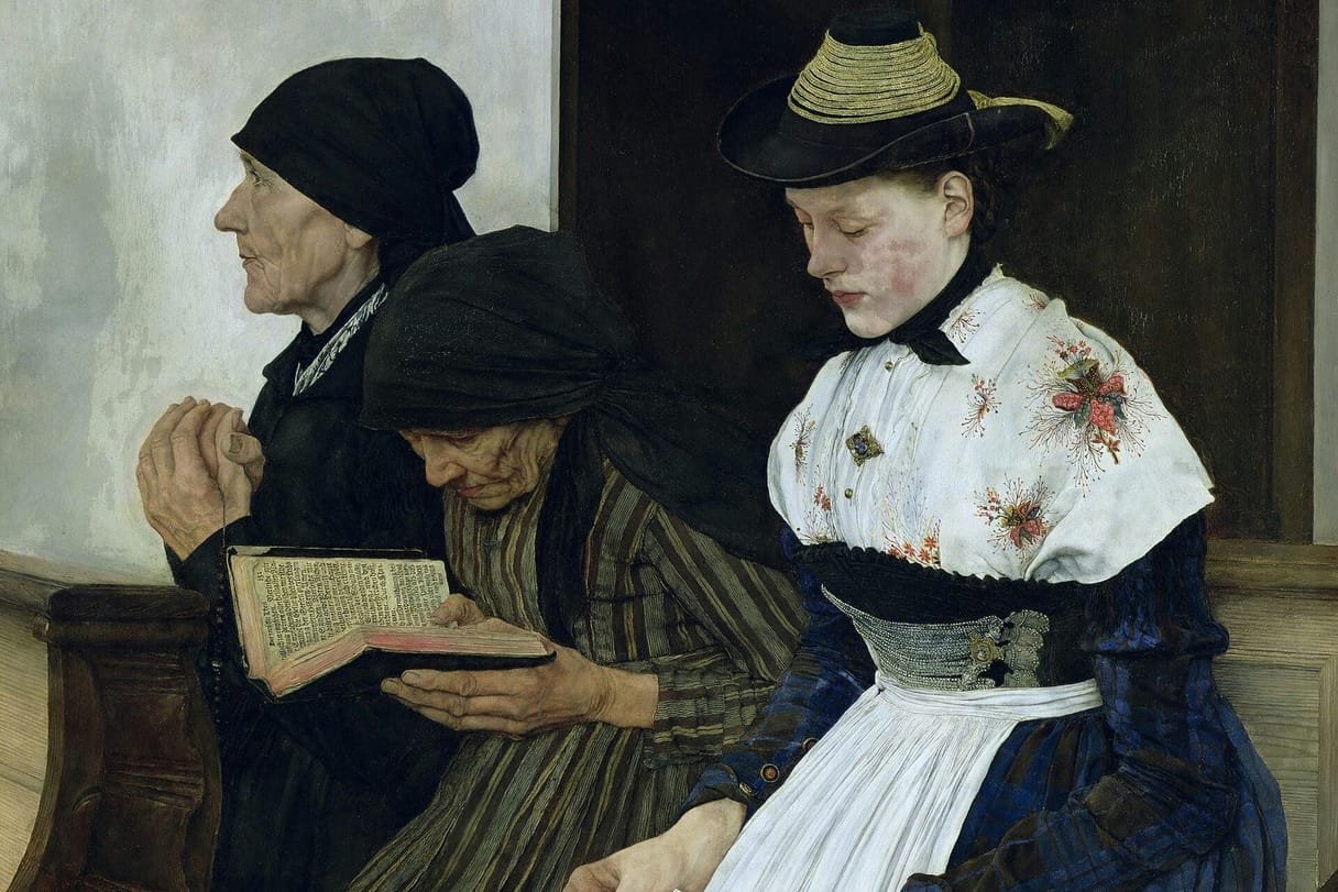 Three women of different ages sit in a carved wooden church pew: an old woman prays with clasped hands, another reads a worn prayer book, and a young woman in a straw hat and embroidered blouse looks down at her book.