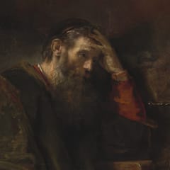 An older bearded man in a dark robe sits at his desk, resting his head on his hand in thought.