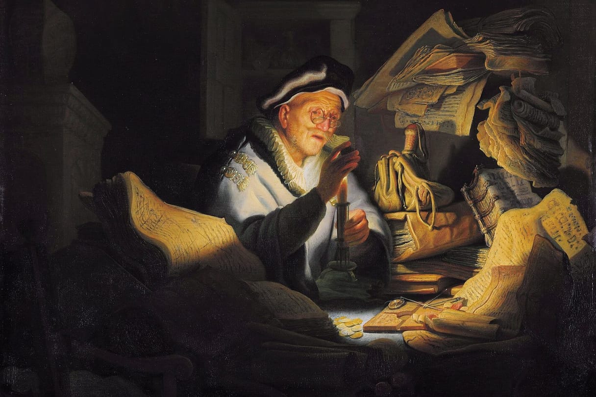 An old man in spectacles and a fur-trimmed robe holds a coin up to a candle, surrounded by heaps of ledgers and papers, money bags, and a small pile of gold coins.