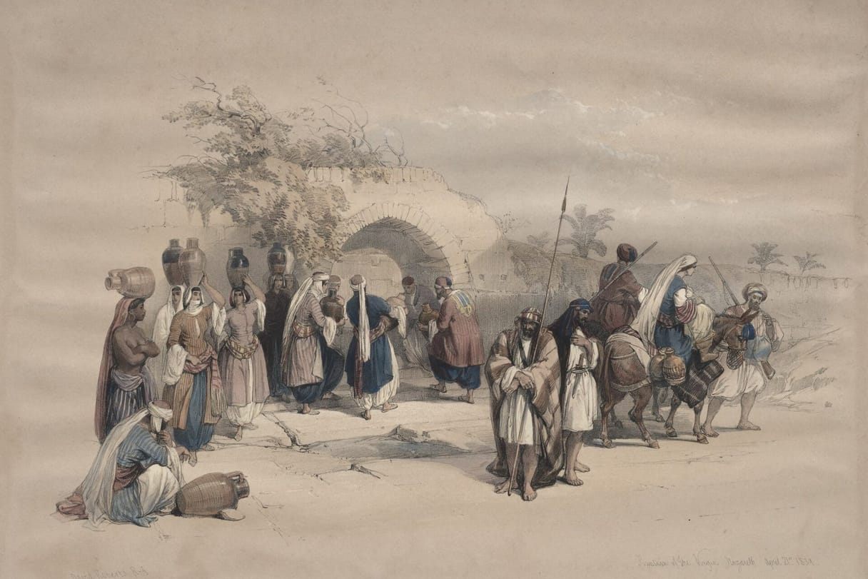 Women carrying water jars gather with travelers and pack animals at a stone well-house in Nazareth.