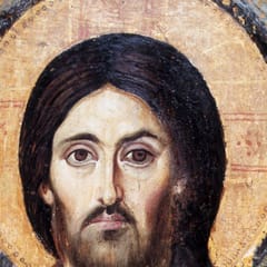An ancient icon shows the face of Christ with long dark hair and a beard, framed by a gold halo.