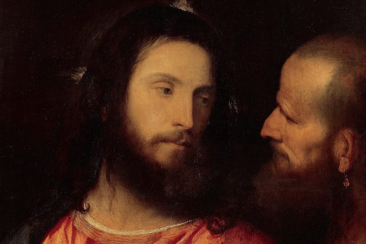 Jesus, in a red robe, looks calmly aside at a bald, bearded man who leans in close beside him.