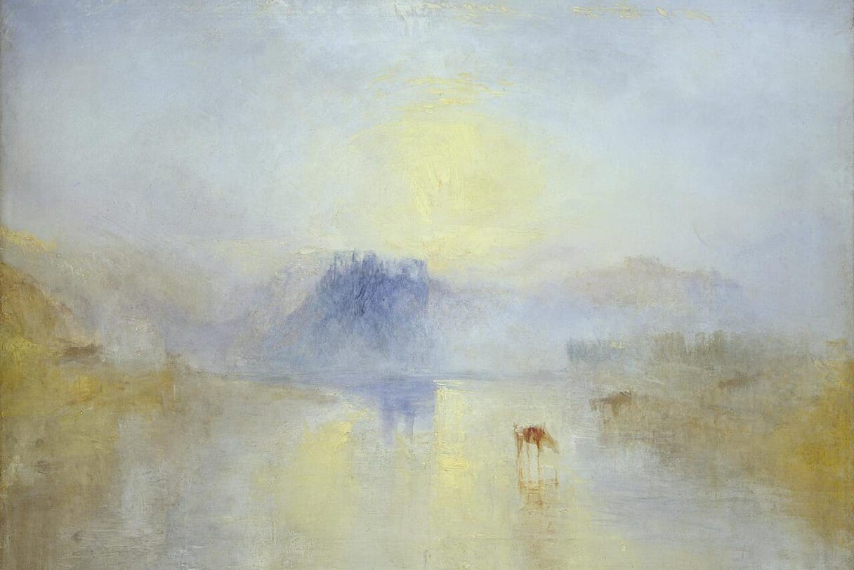 A soft yellow sun rises through mist over a still river, where the blue shape of a castle and a cow drinking at the water are barely visible.