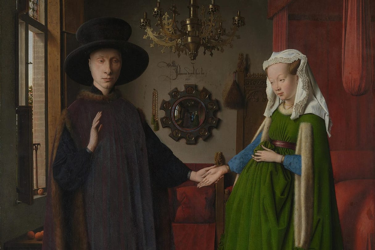 A man in a broad black hat raises one hand and holds his wife’s hand with the other; she wears a full green gown and white headdress, beneath a brass chandelier beside a round mirror.